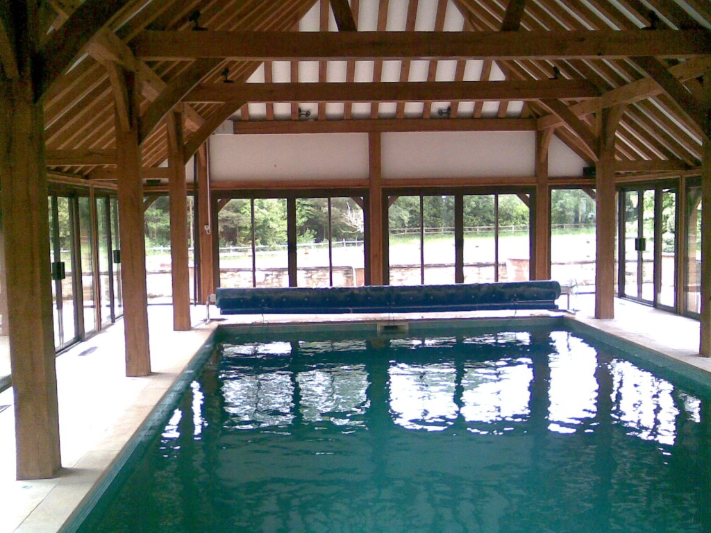 pool inside wooden cover building with cover and reel system