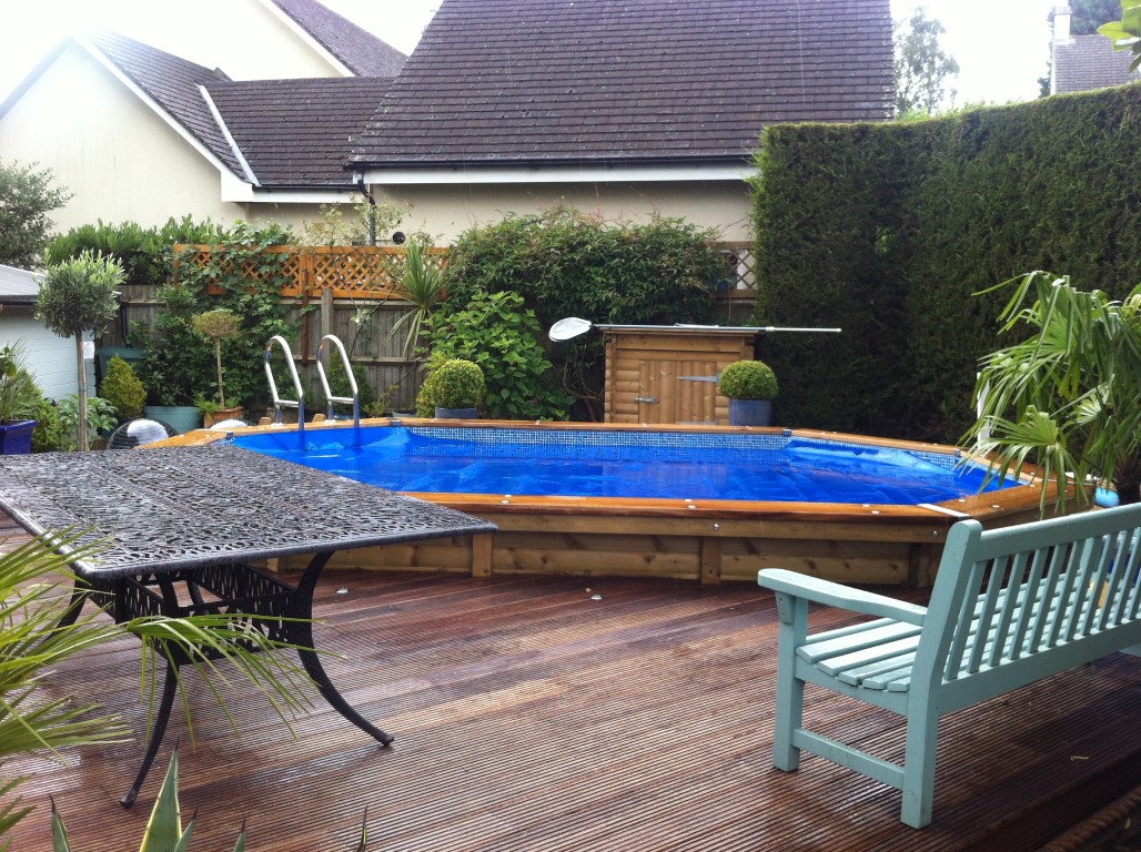 octagonal pool on decking by bench and table