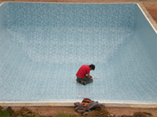Empty outdoor pool with maintenance man in