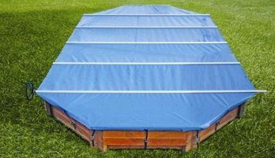 Blue pool cover over wooden pool